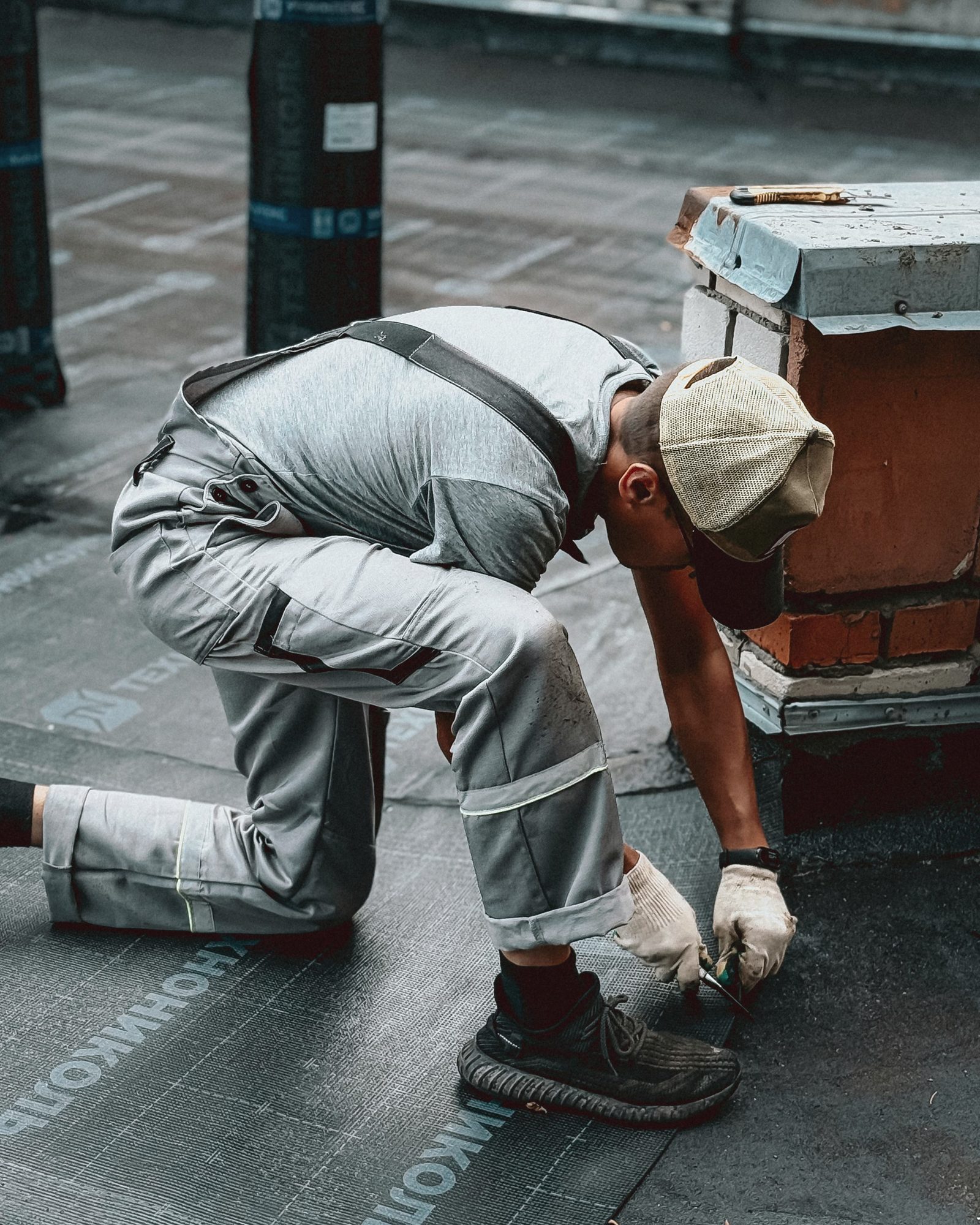 Worker sealing a flat roof terrace with waterproofing membrane